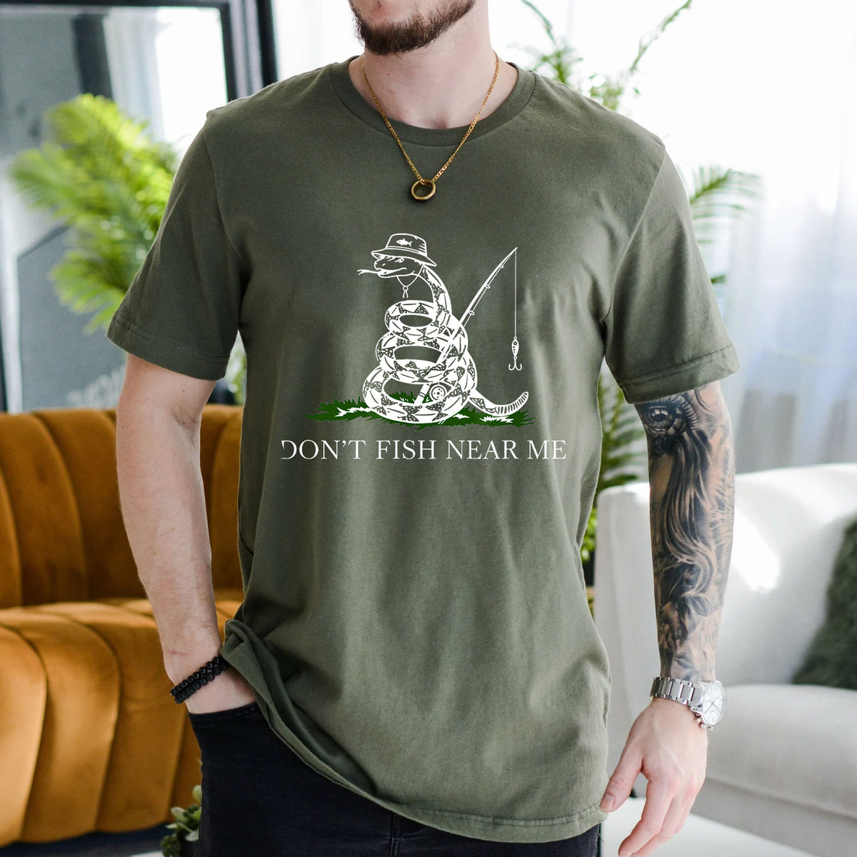 Navy T-shirt front with coiled snake angler holding a fishing rod and lure