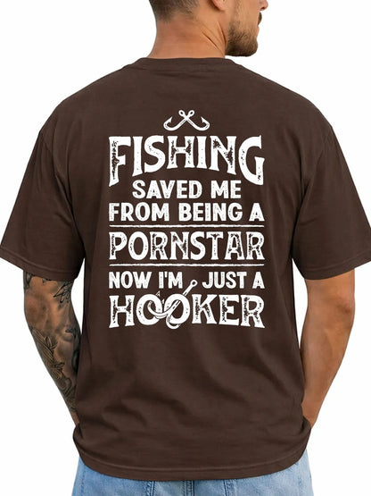 A man viewed from the back wearing a dark brown t-shirt with a humorous white graphic text print that reads 'FISHING SAVED ME FROM BEING A PORNSTAR NOW I'M JUST A HOOKER' with a fishing line and hook design.