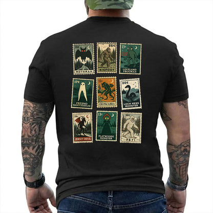 Black T-shirt back with nine vintage-style cryptid stamps featuring Mothman, Bigfoot, and other legendary creatures reading 'MOTHMAN BIGFOOT LOVELAND FROGMAN FRESNO NIGHTCRAWLER CHUPACABRA LOCH NESS MONSTER JERSEY DEVIL FLATWOODS MONSTER YETI'