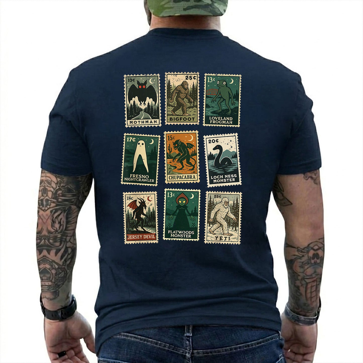 Navy T-shirt back with nine vintage-style cryptid stamps featuring Mothman, Bigfoot, and other legendary creatures