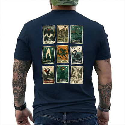Navy T-shirt back with nine vintage-style cryptid stamps featuring Mothman, Bigfoot, and other legendary creatures