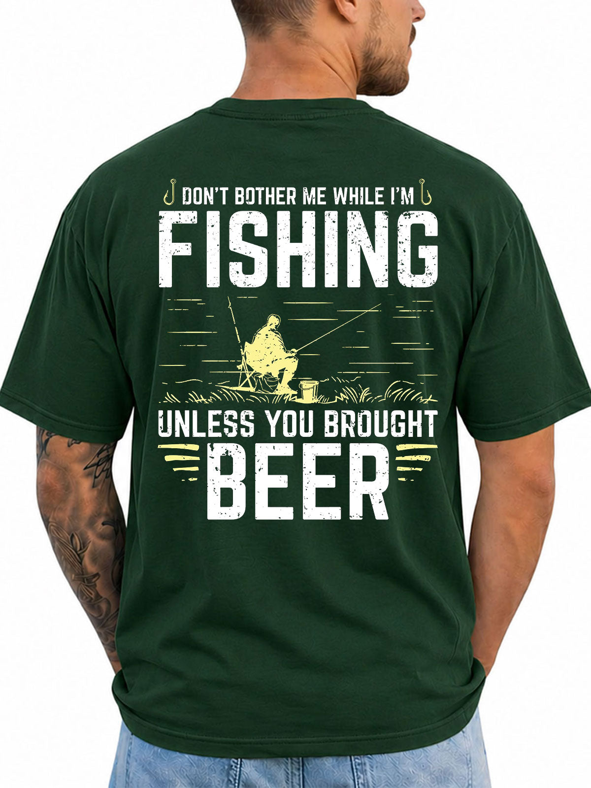Forest green T-shirt back with seated angler and bold fishing slogan artwork