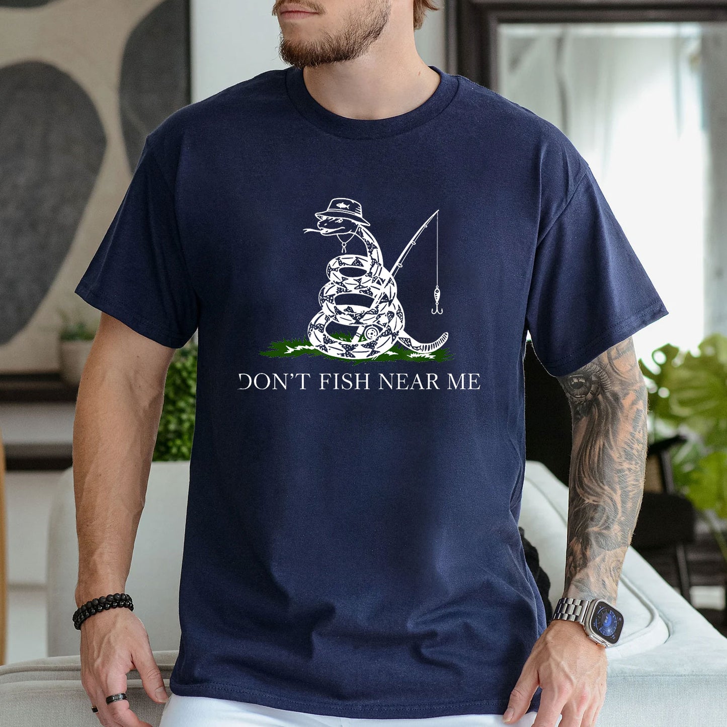 Dark Heather T-shirt front with coiled snake angler holding a fishing rod and lure