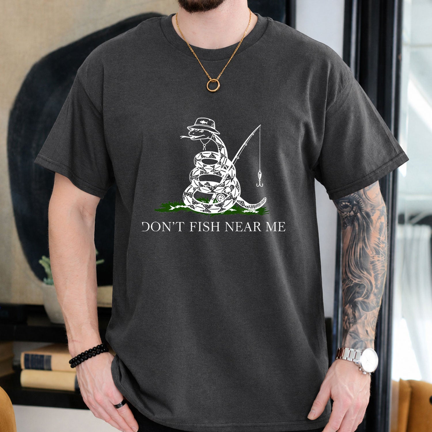 Dark Chocolate T-shirt front with coiled snake angler holding a fishing rod and lure