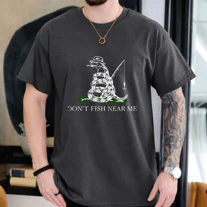 Dark Chocolate T-shirt front with coiled snake angler holding a fishing rod and lure