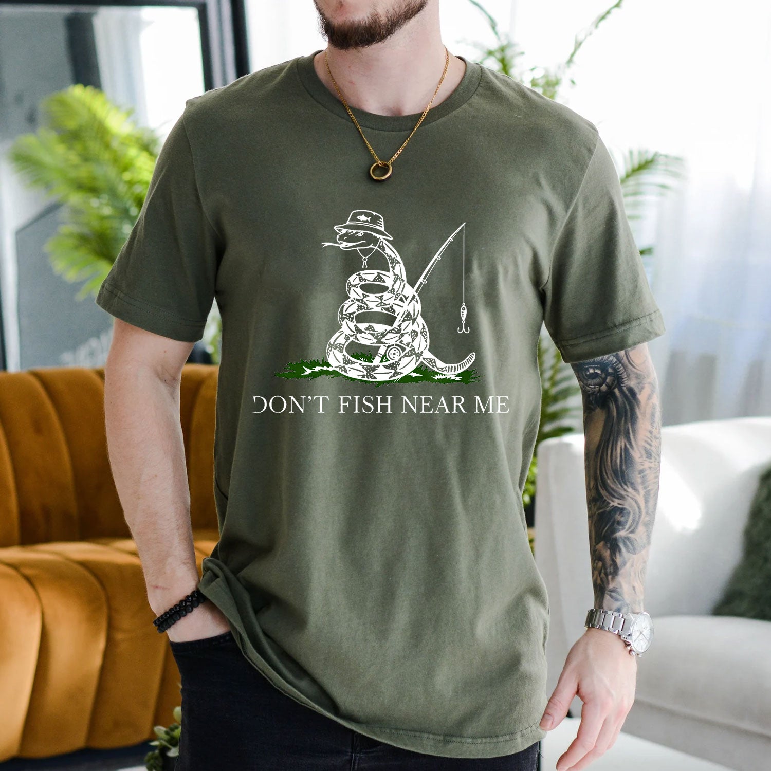 Navy T-shirt front with coiled snake angler holding a fishing rod and lure