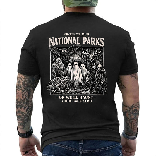 Black T-shirt back with black-and-white cryptid collage with ghosts, Bigfoot, Mothman, a frog, and skeletal figures reading 'PROTECT OUR NATIONAL PARKS OR WE'LL HAUNT YOUR BACKYARD'