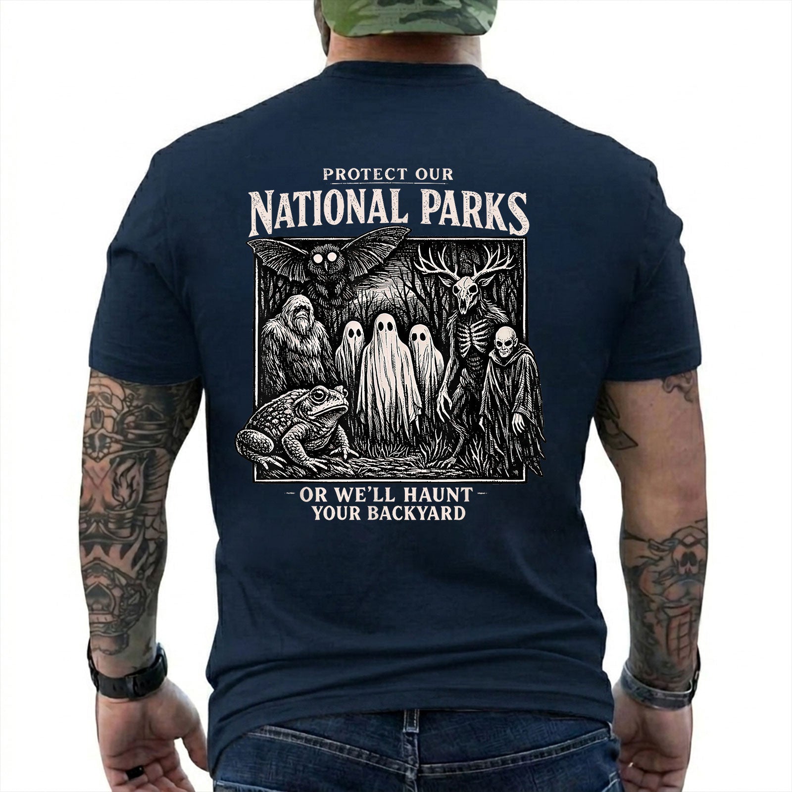 Navy T-shirt back with black-and-white cryptid collage with ghosts, Bigfoot, Mothman, a frog, and skeletal figures