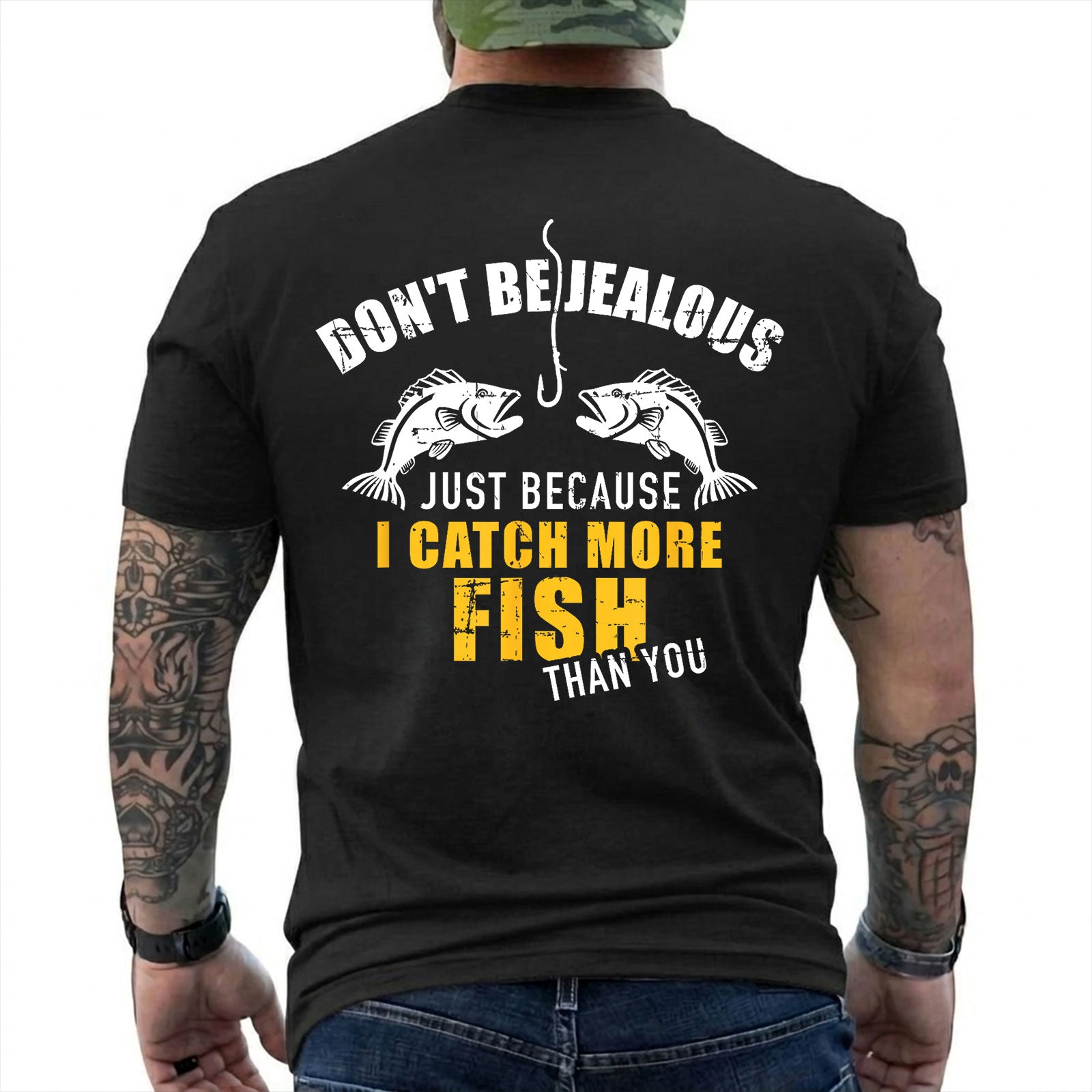 Black T-shirt back with two fish, hook, and I Catch More Fish Than You back slogan reading 'DON'T BE JEALOUS JUST BECAUSE I CATCH MORE FISH THAN YOU'