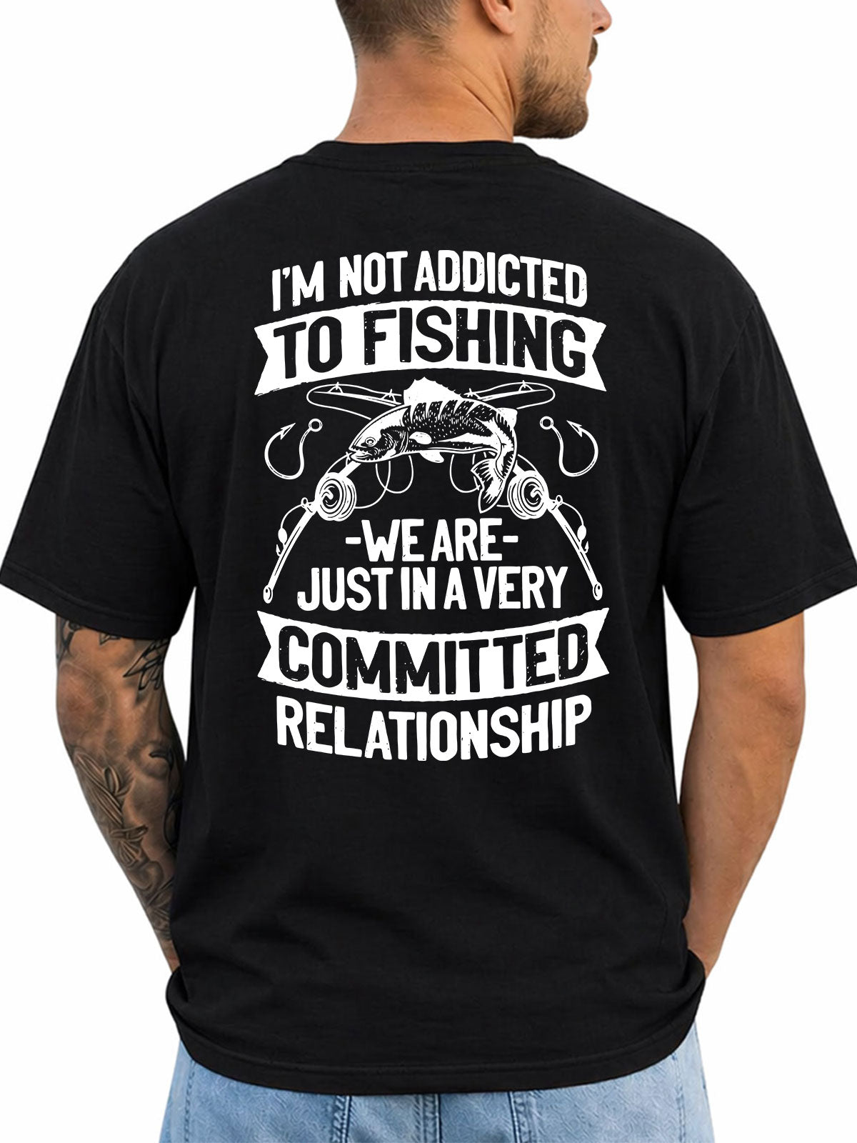 Black T-shirt back with fish, rods, hooks, and committed-relationship fishing joke reading 'I'M NOT ADDICTED TO FISHING WE ARE JUST IN A VERY COMMITTED RELATIONSHIP'