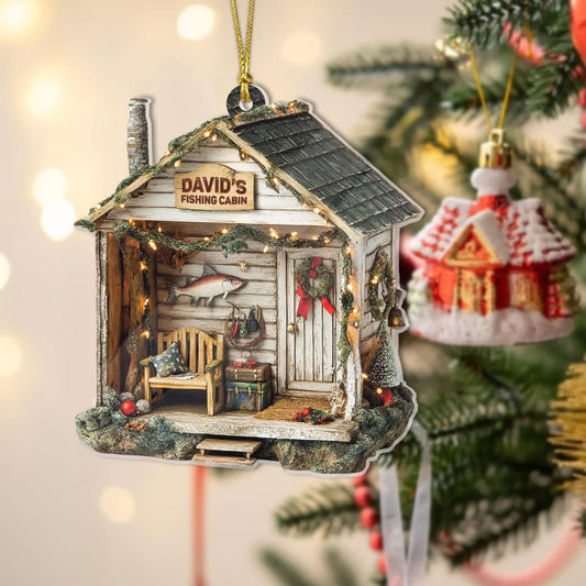 Personalized fishing cabin ornament with a custom name sign hanging on a Christmas tree