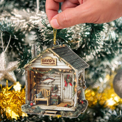 Hand holding a personalized fishing cabin ornament on a Christmas tree