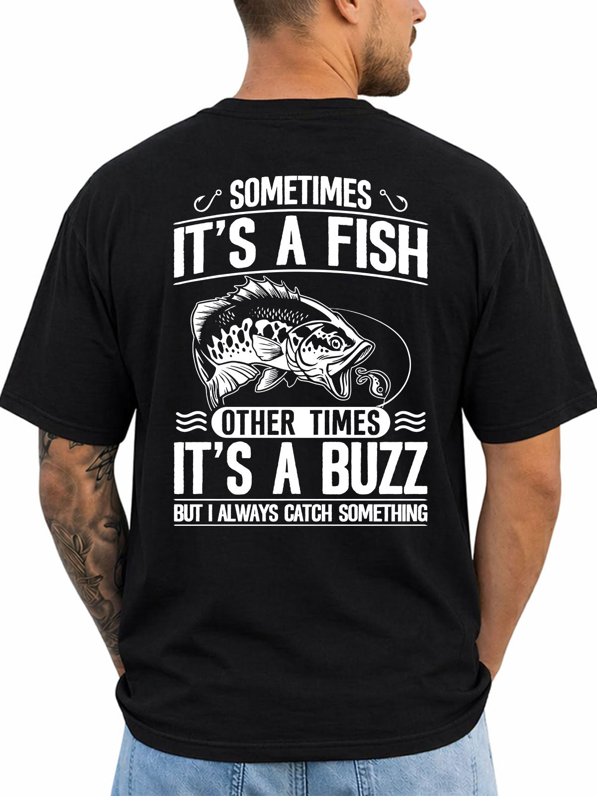 Black T-shirt back with bass, lure, and fish-or-buzz adult fishing joke reading 'SOMETIMES IT'S A FISH OTHER TIMES IT'S A BUZZ BUT I ALWAYS CATCH SOMETHING'