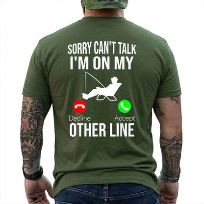 Military Green T-shirt back with seated angler, fishing line, and phone-call Other Line joke