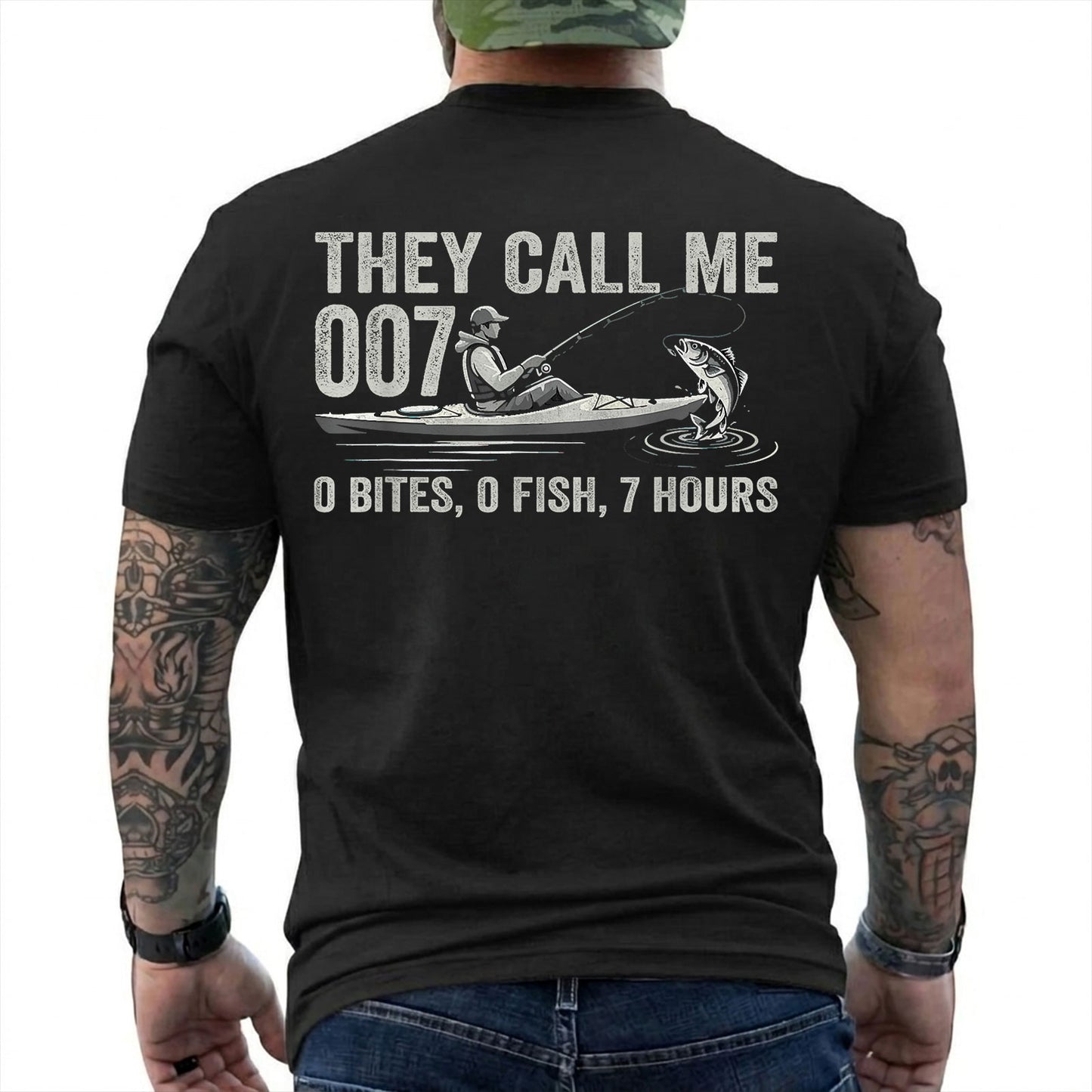 Black T-shirt back with kayak angler, jumping fish, and 0 bites 0 fish 7 hours joke reading 'THEY CALL ME 007 0 BITES, 0 FISH, 7 HOURS'