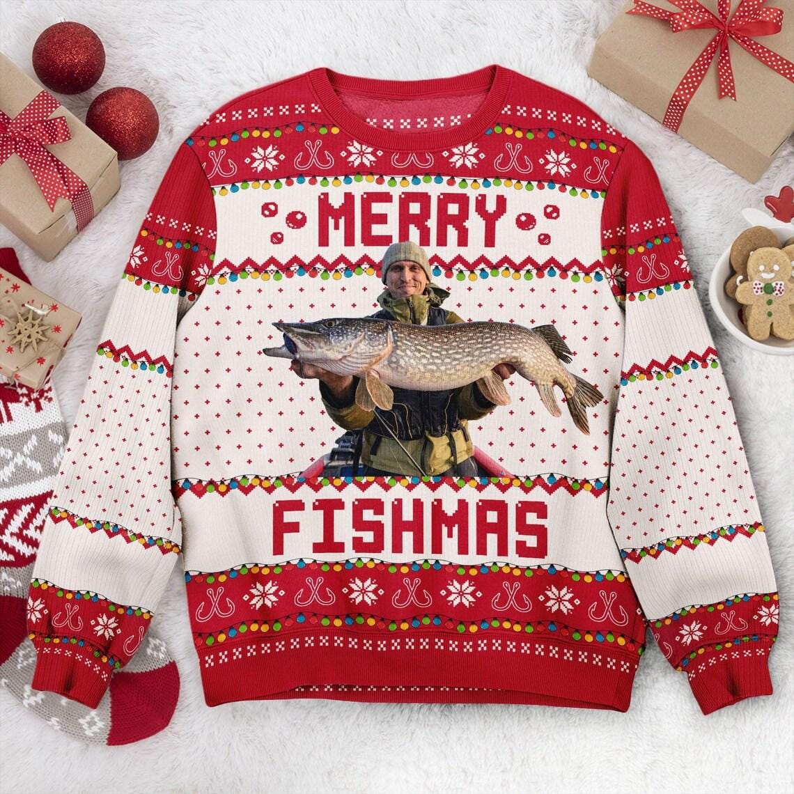Cream Merry Fishmas sweater flat with a beanie-wearing angler and a pike