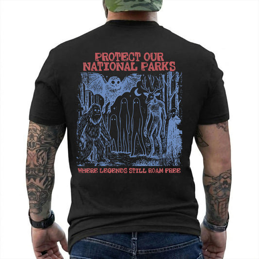 Black T-shirt back with blue forest cryptids beneath red Protect Our National Parks lettering reading 'PROTECT OUR NATIONAL PARKS WHERE LEGENDS STILL ROAM FREE'